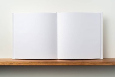 Kitaplık ta kare beyaz defter ve mockup için beyaz duvar