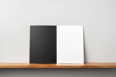 Siyah dergi kitapçık ve mockup için gri duvar üzerinde duran