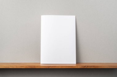 A4 dergisi kitapçık ve mockup için gri duvar üzerinde duruyor