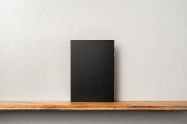 Siyah dergi kitapçık ve mockup için gri duvar üzerinde duran