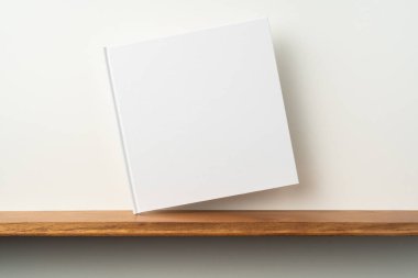 Kitaplık ta kare beyaz defter ve mockup için beyaz duvar