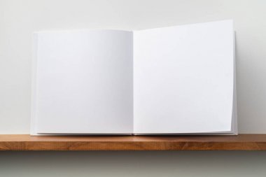 Kitaplık ta kare beyaz defter ve mockup için beyaz duvar