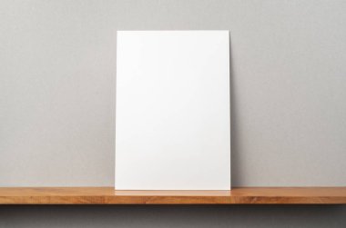 Maket için kitaplık ve gri duvar üzerinde duran A4 kağıt ön görünümü