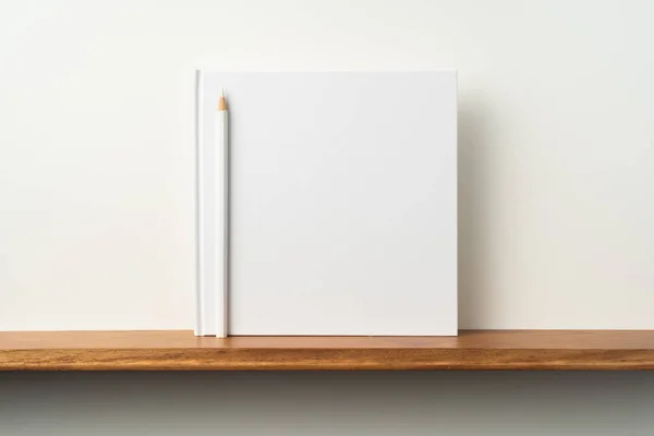 Szögletes Fehér Notebook Ceruzával Könyvespolc Fehér Fal Mockup — Stock Fotó
