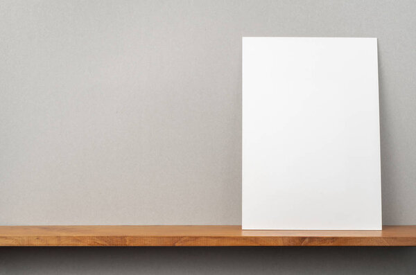 A4 hard paper standing on bookshelf and grey wall for mockup