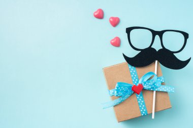 Hediye kutusu ile Babalar gün düzeni, gözlük ve bıyık silueti, pembe kalpler, mockup için kopya alanı.