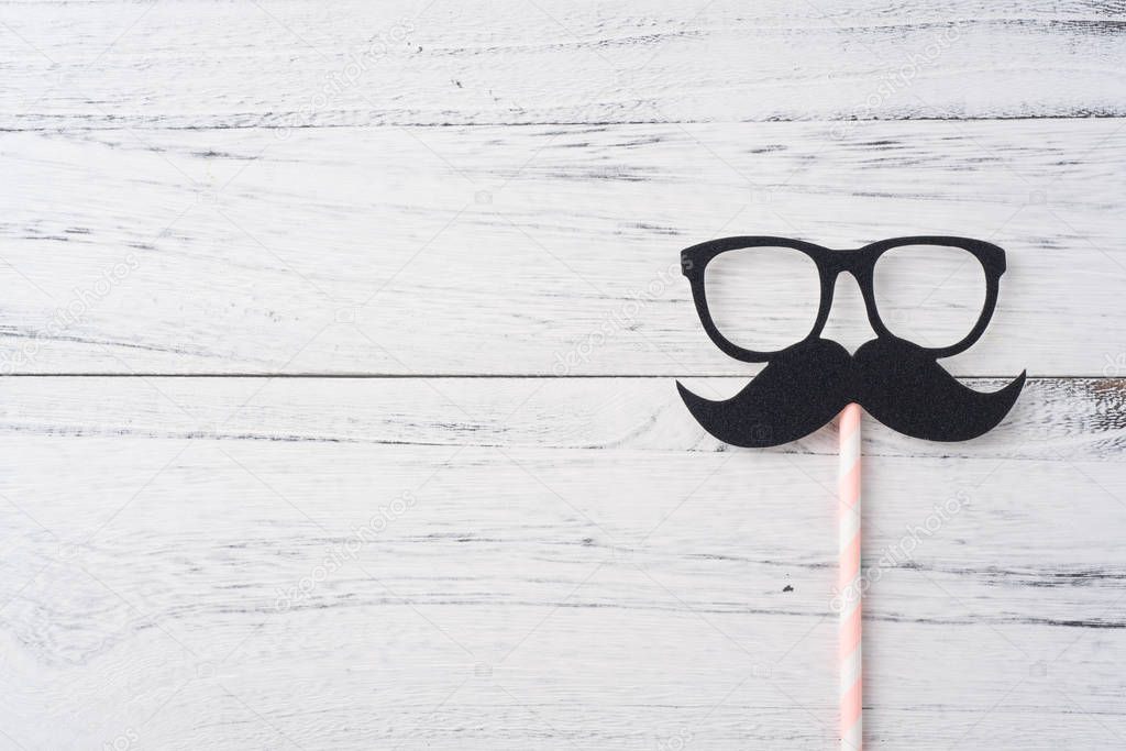 Fathers day layout with eyeglasses and mustache on white wooden background