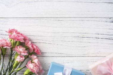 Anne gün mockup için hediye kutuları ile beyaz Vintage ahşap arka planda pembe karanfil demet