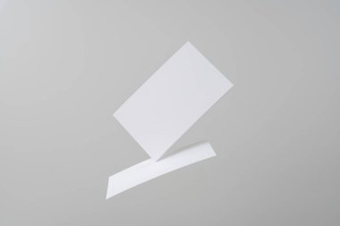 Mockup için gri arka planda havada uçan beyaz kartvizitler