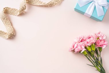 Karanfil demet, hediye kutusu ve Vintage bej şerit anne gün mockup için pembe arka planda