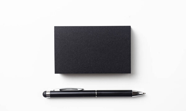 Top view of black business card with ball point pen isolated on white background for mockup