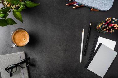 Mockup için siyah arka planda Saksı bitki, Gözlük, kahve, kalem ve Notebook ile masa.