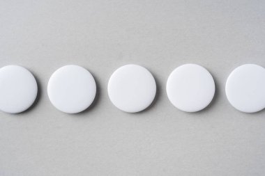 Maket için dokulu gri arka plandaki beyaz rozetlerin üst görünümü