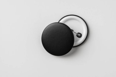 Beyaz arkaplanda izole edilmiş ön ve arka siyah rozetlerin üst görünümü