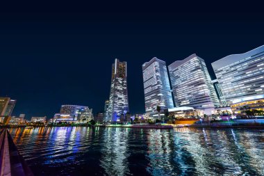 Gayrimenkul ve şirket inşaatı için Asya iş konsepti - panoramik modern şehir gökyüzü geceleyin Yokohama, Japonya 'da.