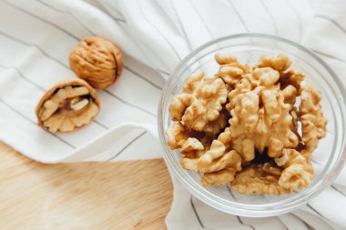Ceviz çekirdekleri mutfak masasındaki yuvarlak kasenin içinde, yakın plan. Sağlıklı yaşam tarzı kavramı.