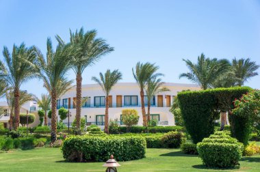 Otelin bölgesi. Mısır 'daki otel kompleksi turizm sezonunun açılışı için hazır. Evin yakınında bakımlı yeşil bir alan. Peyzaj.