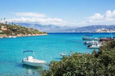 Gök mavisi berrak suyla dolu bir körfeze demirlemiş tekne ve yatlar. Deniz yolculuğu.