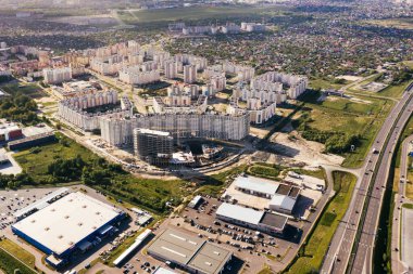 Ev inşaatı, şehrin çok katlı yerleşim alanı. Gün batımında Çok katlı evlerin havadan görünüşü. Emlak, yüksek binalar. Geliştirme Endüstrisi.