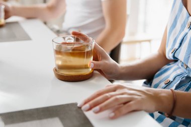 Aile kahvaltısı. Elinde bir fincan çay tutan kadın, yakın plan..