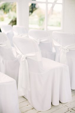 Düğün ya da şenlik için dekorun bir parçası olarak beyaz sandalyeler. Düğün konsepti.