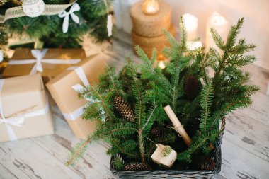 Noel dekorunun ve mumların arka planında köknar dalları olan bir sepet. Seçici odak.