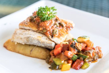 Patates üzerinde ızgara sebzeli ızgara levrek balığı