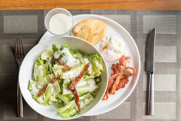 Sezar Salatası Hizmet Ile Gevrek Domuz Pastırması Yumurta Kaçak Avlanmak — Stok fotoğraf