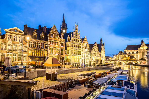 Picturesque medieval buildings on Leie river in Ghent town, Belgium at dusk.