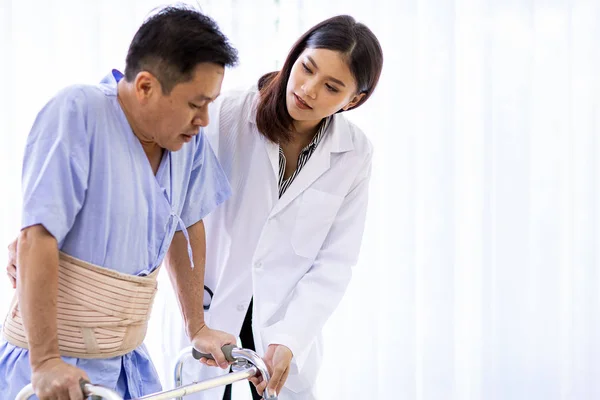 Lady doctor help elderly using adult walker in hospital