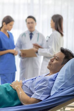 Endişeli hastayla profesyonel takım doktorlar arka planda yatakta