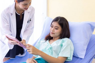 Asyalı Doktor rutin sağlık hasta hastane koğuşunda dijital Tablet kullanma ile kontrol yapmak