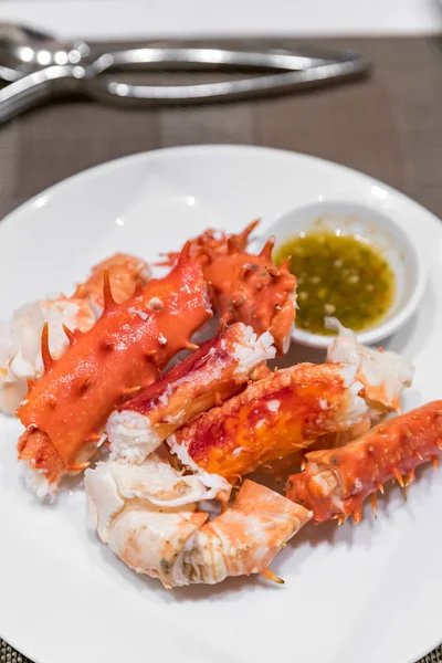 Alaskan king crab and seafood on white dish with seafood sauce