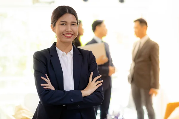 亚洲女商人的肖像与商业团队在办公室窗口的背景使用为公司工作背景 — 图库照片