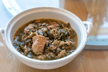 Tayland Chamuang domuz çorbası, kova yapraklı domuz eti, ahşap arka planda Tayland geleneksel yemek mutfağı.