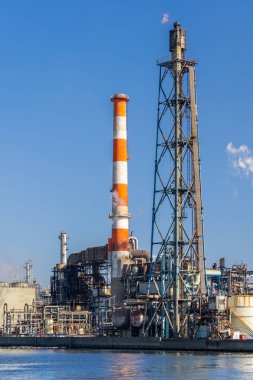 Tokyo yakınlarındaki Kawasaki City 'deki bacadan çıkan dumanla gaz depolama ve boru hattının yapısına sahip petrol petrokimya fabrikası.