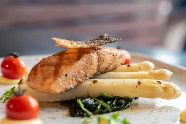 Izgara somon fileto ile ızgara beyaz kuşkonmaz domates ve ıspanak ile hizmet
