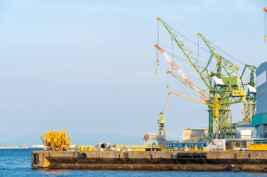 Kobe Hyogo Kansai Japonya'daki Limanın sanayi bölgesinde vinçlerin istiflenme stohruna sevkiyat ve küresel iş geçmişi için kullanılması 