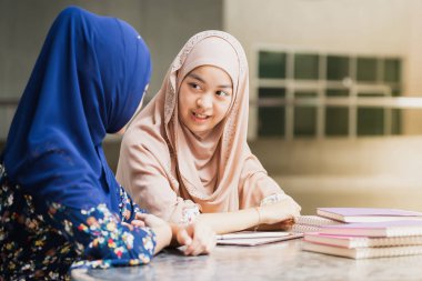 Genç Yetişkin Asya Müslüman üniversite öğrencisi birlikte eğitim kavramı için kullanarak kitap okuma