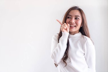 Beyaz arka planda kış için beyaz kazak giyen güzel Asyalı yetişkin bir kızın portresi.