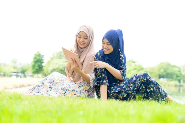 ソーシャルメディアでスマートフォンやタブレットを使用して若い大人のティーンエイジャーイスラム教徒イスラム教徒タイのアジアの女性 — ストック写真