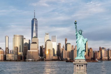 New Jersey 'den günbatımında New York şehrinin arka planına sahip Özgürlük Anıtı. 