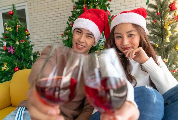 若いですアジアの大人のティーンカップルお祝いクリスマス休暇でワインと一緒にリビングルームでクリスマスツリーの装飾 — ストック写真