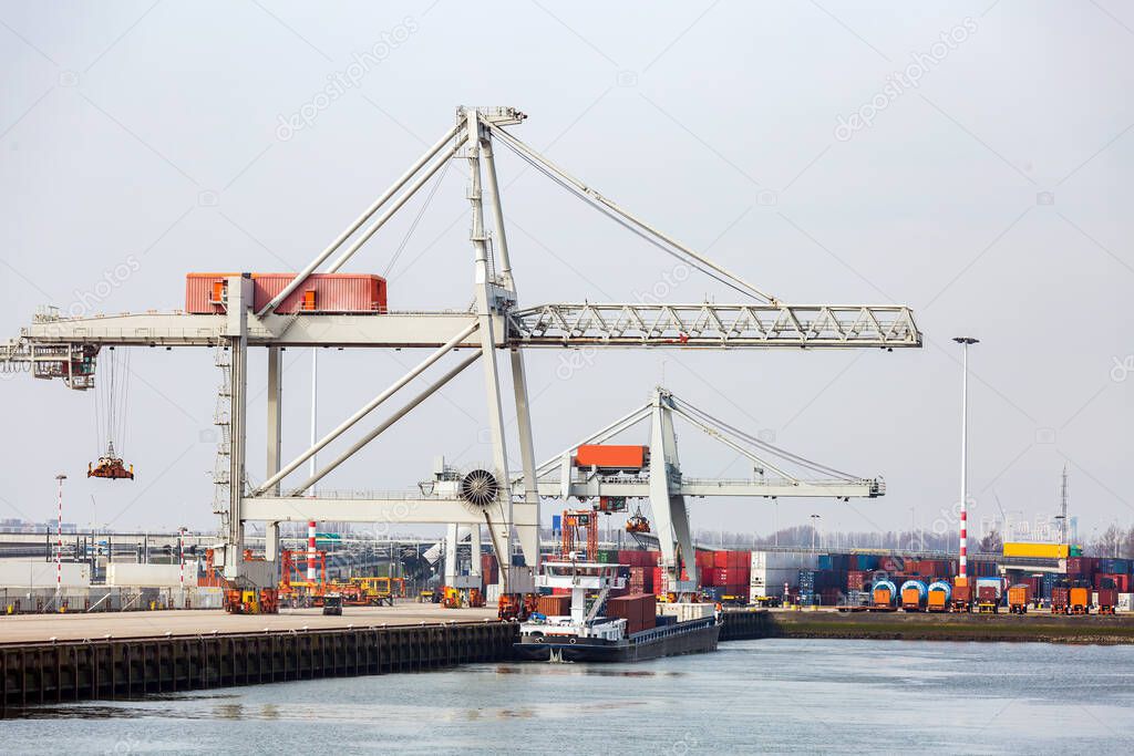 Big Cargo Containers Boat with Goods cargo Stack at the Pier docks port waiting for international sea freight transportation in Rotterdam Port of Netherlands