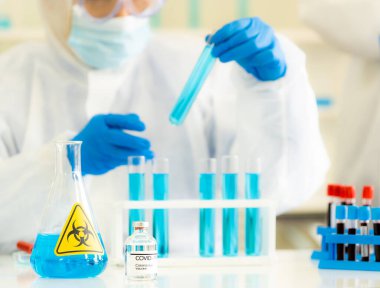 Coronavirus COVID-19 Aşısı. Ncov-2019 dünya salgınına karşı araştırma ve aşı geliştirmek için çalışan ve dinlenme tüpü tutan bilim adamlarının geçmişine sahip. Tıbbi teknoloji ve sağlık hizmeti kavramı.