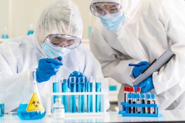 Bilim insanları Coronavirus covid-19 salgınına karşı araştırma ve aşı geliştirmek için tüp rafında kimyasal reaktör bırakmak için damlatıcıyı kullanıyorlar. Tıp bilimi ve teknoloji konsepti.