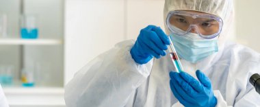 Panoramik bilimciler, Coronavirus covid-19 salgınına karşı araştırma ve aşı geliştirmek için kan örneğiyle test tüpü tutuyorlar. Tıp Bilimi Sağlık ve Teknoloji Konsepti.