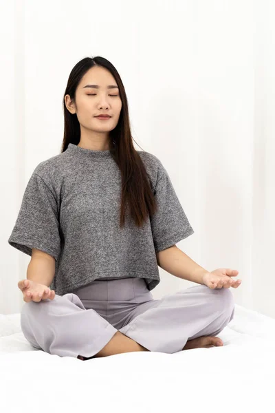 アジアの女性は コロナウイルスCovid 19パンデミックからの都市のロックダウンからの良好な精神衛生上の原因のためのストレスと緊張を緩和し 軽減するために瞑想を行います 瞑想リラックスしてレジャー活動のコンセプト — ストック写真