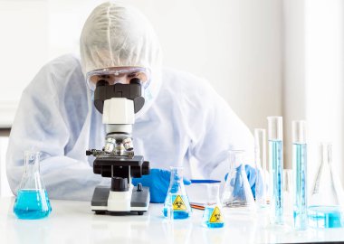 Genç Asyalı bilim adamı, 2019 ncov dünya pandemisi için Coronavirus COVID-19 aşısını incelemek üzere laboratuvarda mikroskop araştırması yapıyor. Sağlık hizmetleri kavramı.