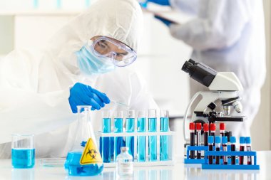 Bilim insanları Coronavirus covid-19 aşısını araştırmak ve geliştirmek için tüp rafta kimyasal reaktör bırakmak için ilaç kullanıyorlar. Tıp Bilimi konsepti.